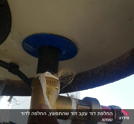 שסתום פליז מחובר לדוד שמש עם אצבע מצביע